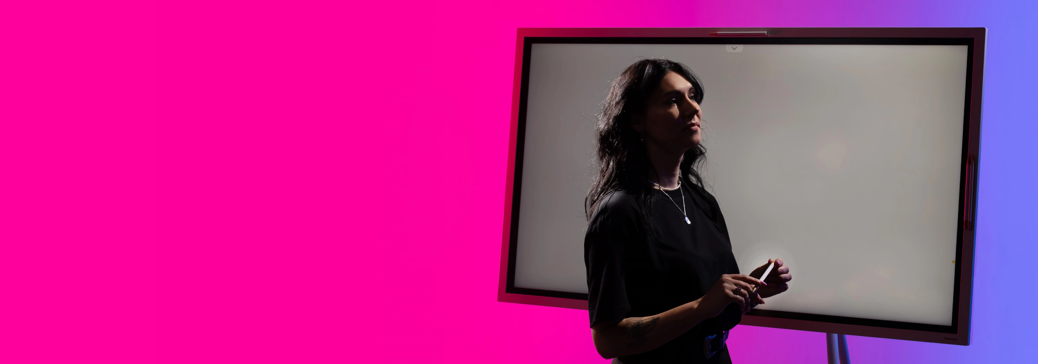 A lecturer stands against a stylized background next to a whiteboard, possibly preparing for lectures at the faculty.