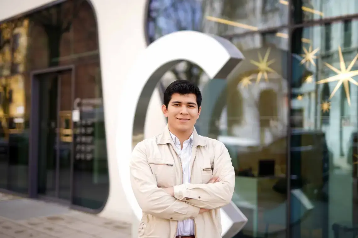 Gerson David Pinto Chica, a student, standing next to a modern office building in Kaunas center.