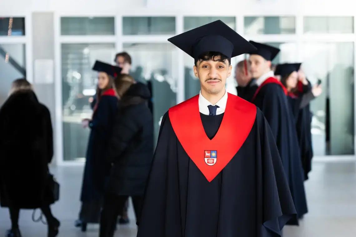 Omar Limi, a student from Italia, seen standing next to the entrance of the university with a graduation gown.