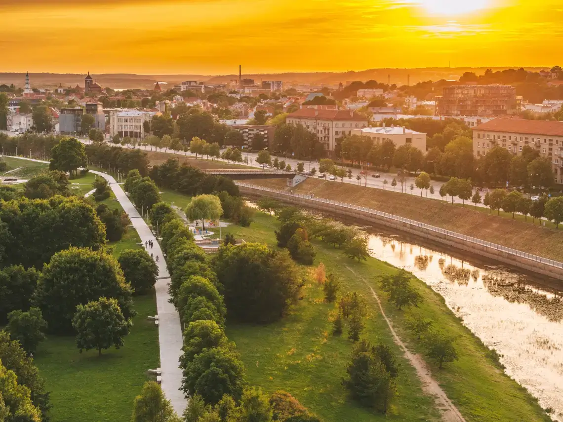 Panoramic view of Kaunas city center filled with greenery and stunning architecture in the summer evening lighted by sun.