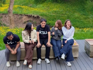 A group of international students sitting on the bench outside representing Study in Kaunas.