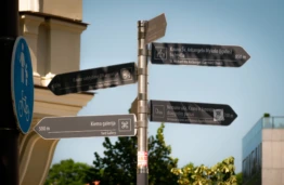 Road signs on Laisvės alėja point toward major city landmarks and destinations.