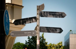 Road signs on Laisvės alėja point toward major city landmarks and destinations.